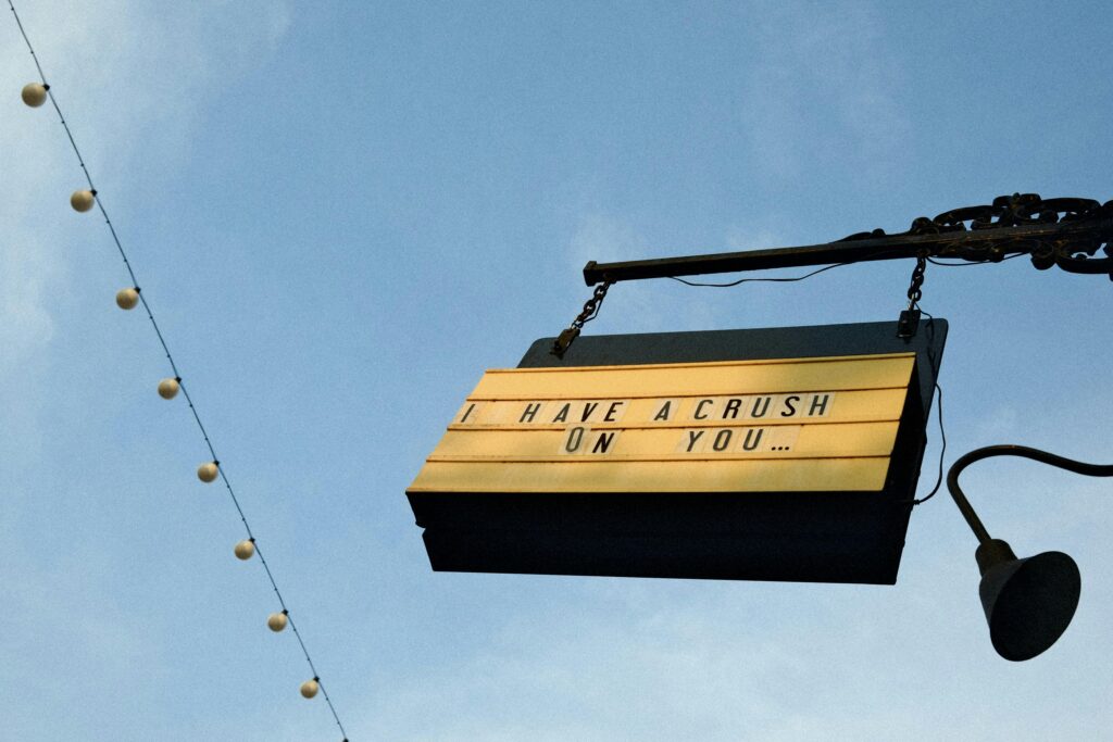 A romantic sign reads 'I have a crush on you' under string lights, evoking charm and nostalgia.